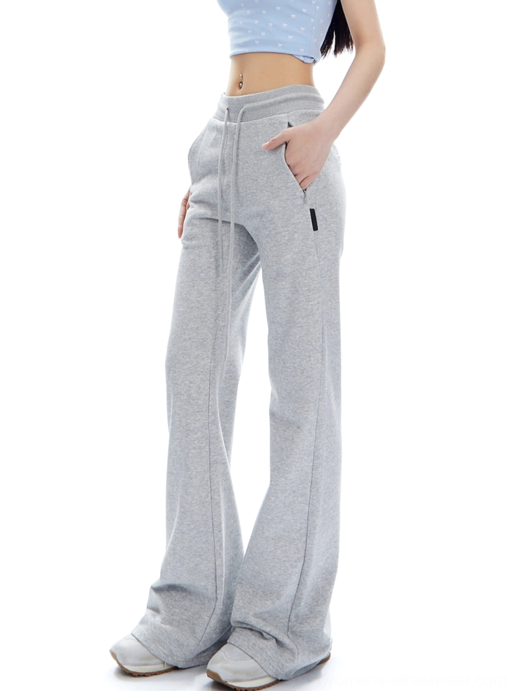 Flower Ash high-waist flared streetwear sweatpants shown from a three-quarter side angle with exposed drawstring and relaxed flared fit