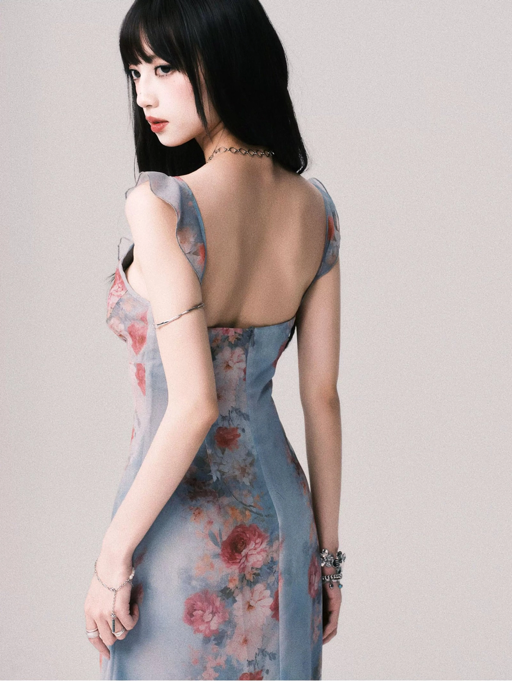 Back three-quarter close-up of foggy blue floral slip dress showing open back design fitted bodice and ruffled shoulder straps