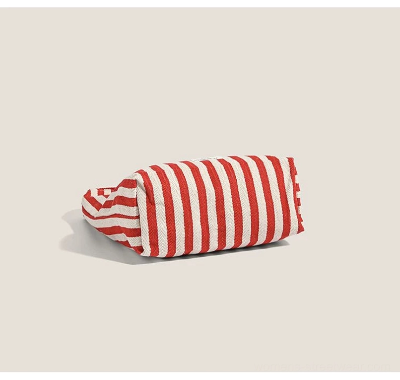Folded red and off-white striped canvas hobo bag displaying durable woven canvas texture and compact storage profile