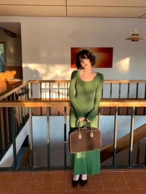Forest green ribbed wool blend u-neck long sleeve maxi dress shown in a full body front view in a warm indoor stairwell