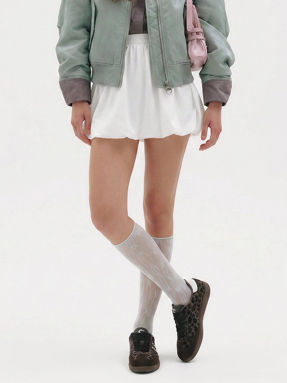 Forest leopard print gum sole sneakers styled with a light green jacket, white mini skirt, sheer socks, and a pink crossbody bag