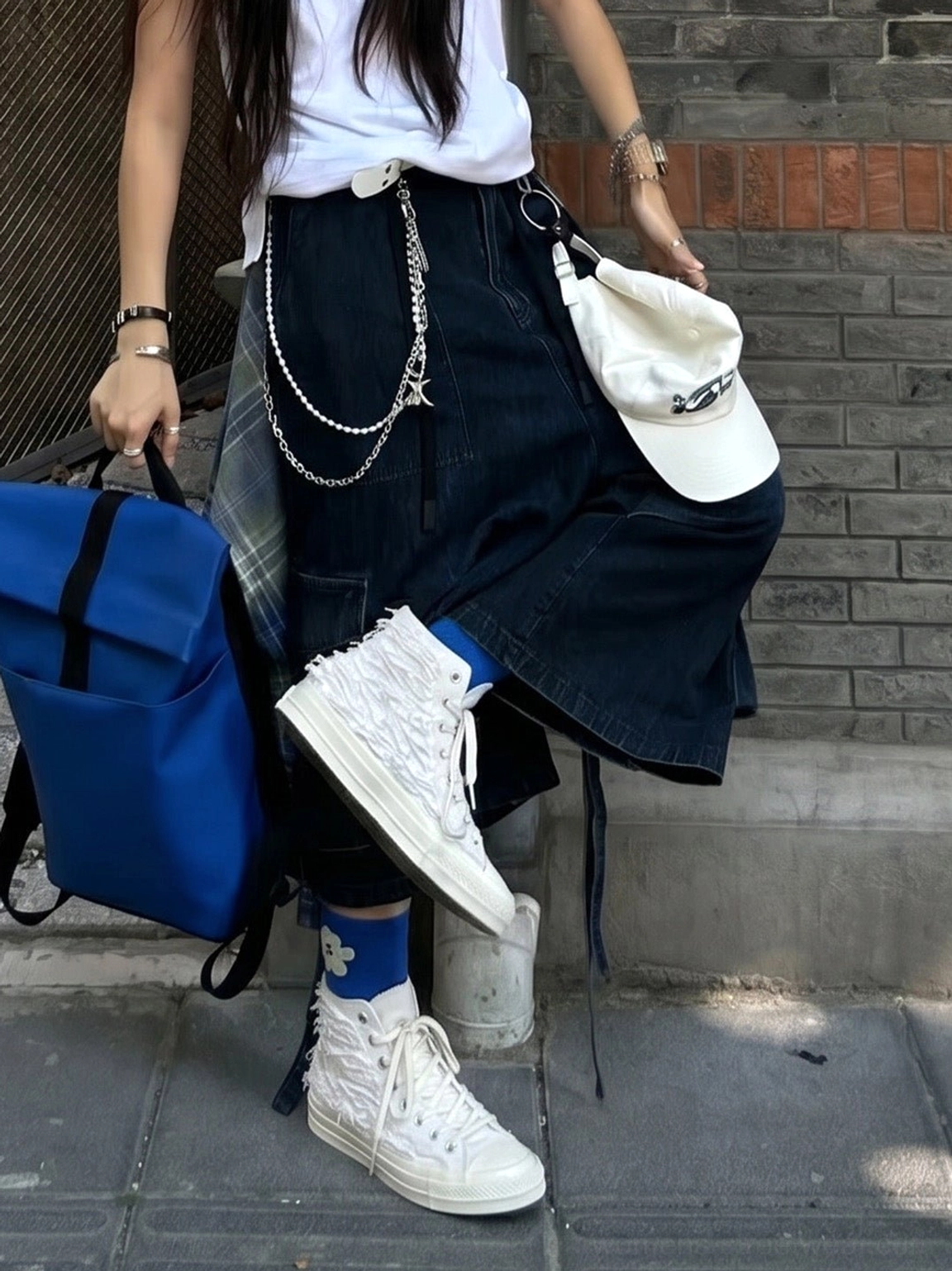 White fringed high-top canvas sneakers styled with white crew socks, denim skirt and Y2K streetwear accessories
