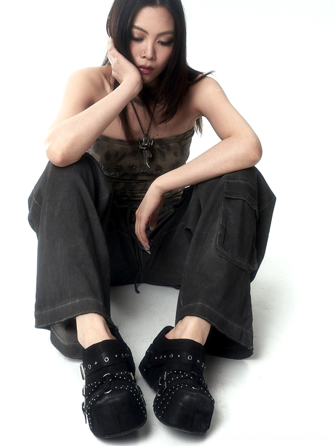 Front view of black closed-toe studded platform mules styled with cargo pants and contemporary streetwear