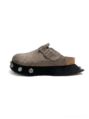 Gray taupe frosted suede platform buckle clogs with cork footbed and studded chunky black sole on white background