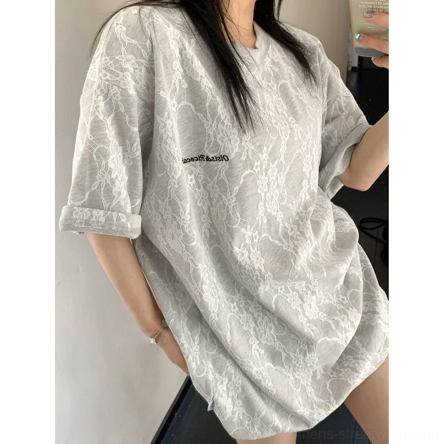 Close-up of grey frosted vein lace texture oversized streetwear t-shirt with crew neck rolled cuffs and chest lettering