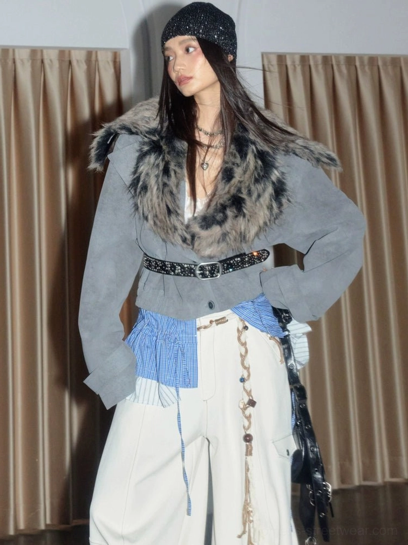 Front view of a light gray faux fur collar cropped jacket with suede-look body and blue plaid pleated hem styled with white wide-leg pants