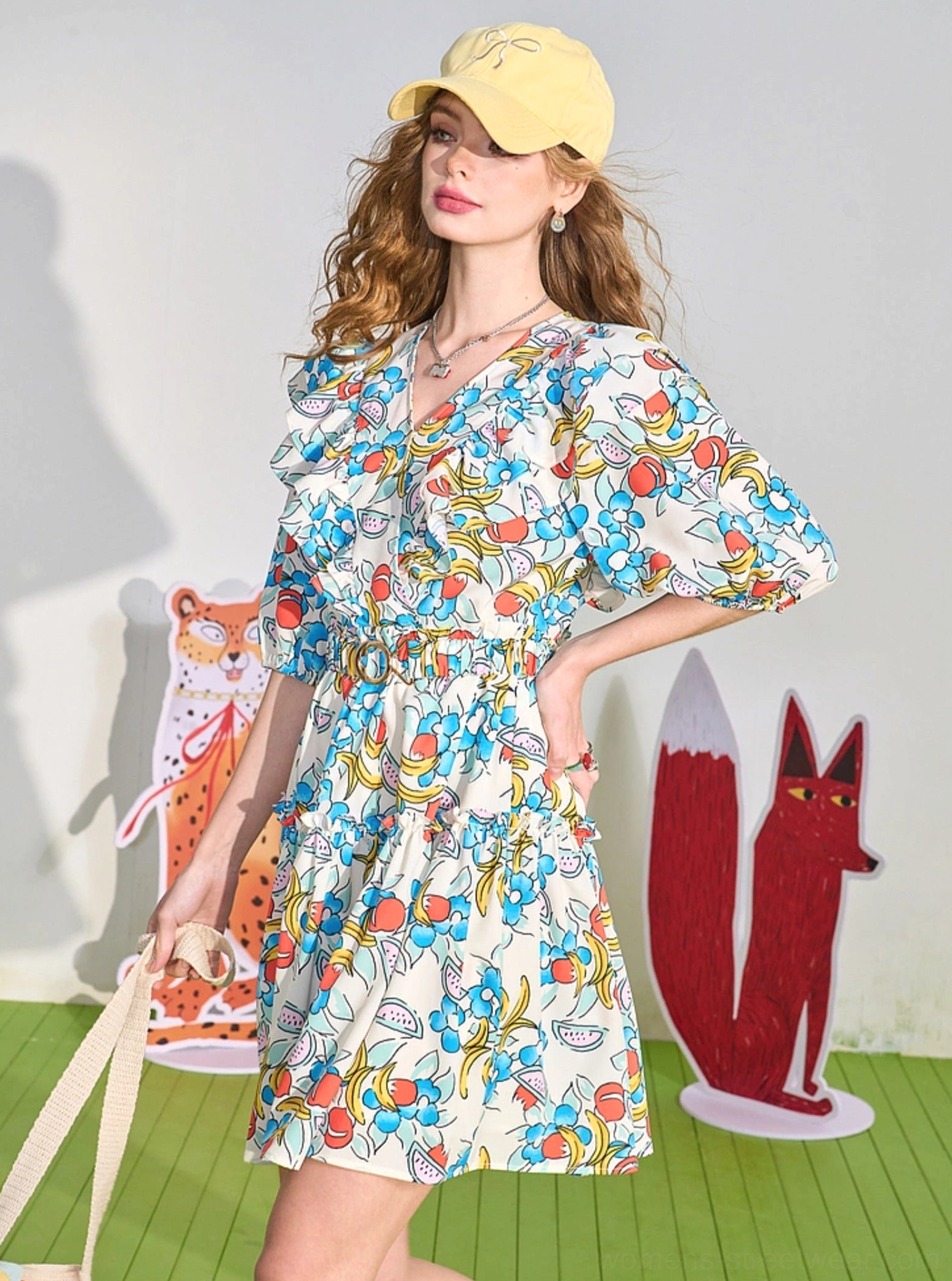 Three-quarter back view of women's fruit print mini dress with puff sleeves and tiered ruffle skirt styling
