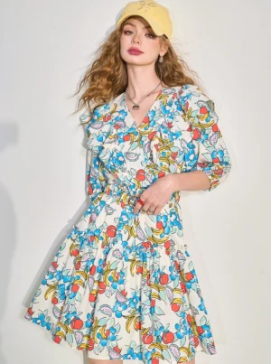 Front view of a women's fruit print ruffle V-neck mini dress with puff half sleeves, elastic waist, and tiered ruffle hem