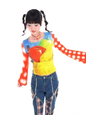 Front three-quarter view of a colorful fruit print Y2K cropped blouse with red polka dot bell sleeves and fitted streetwear silhouette
