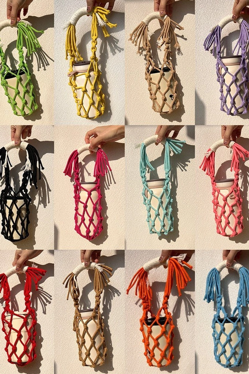 Full color range of hand-knotted cotton macrame water bottle carriers held by hands, featuring tassel handles and flexible net pockets