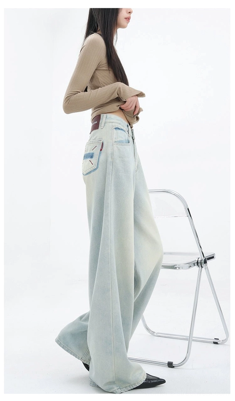 Full-length light blue denim streetwear pants with a relaxed straight silhouette and subtle artistic detailing