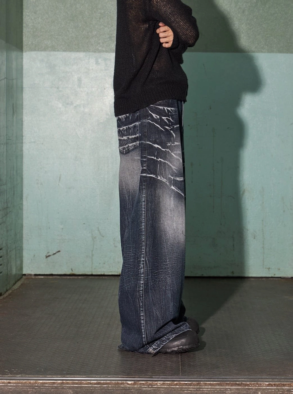 Side rear view of full-length lightning wash wide-leg denim with a relaxed oversized streetwear fit