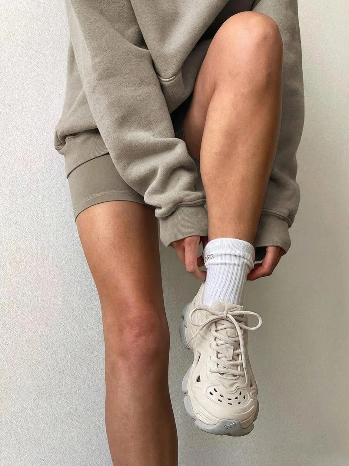Close-up of off-white futuristic platform clog with perforated toe box, lace-up front, and grey rugged outsole