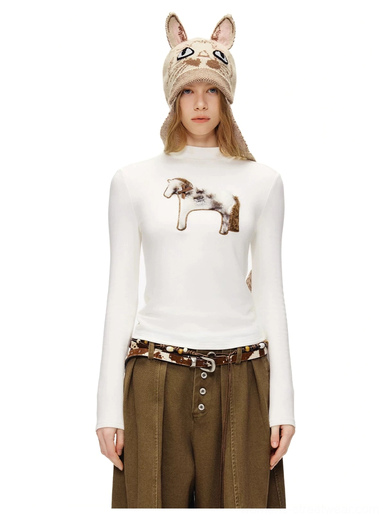 White fuzzy cat mock neck long sleeve tee with standing cat detail styled with brown wide-leg pants and knit cat hat