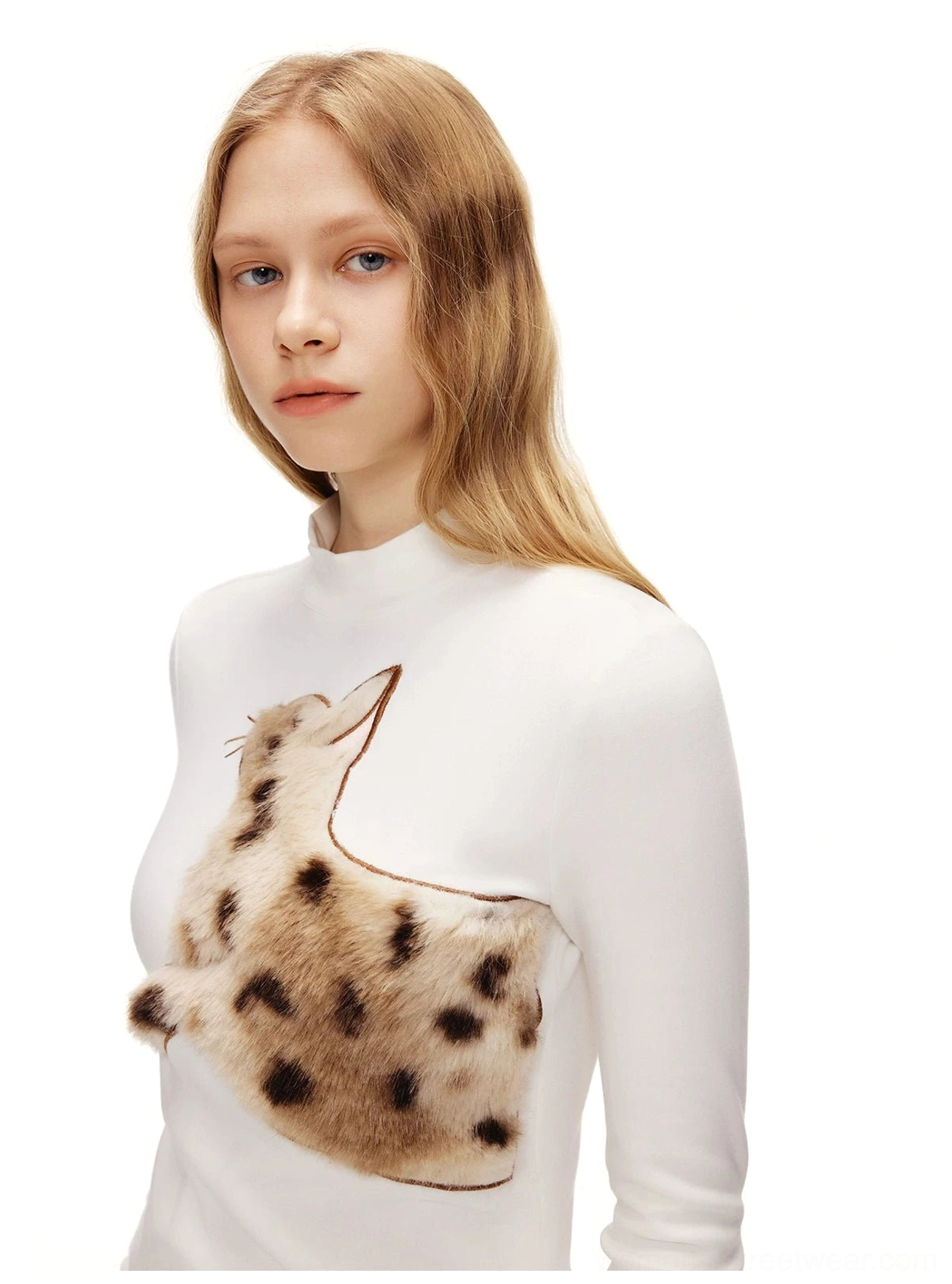 Close-up of a white fitted mock neck long sleeve tee with oversized three-dimensional fuzzy spotted cat appliqué