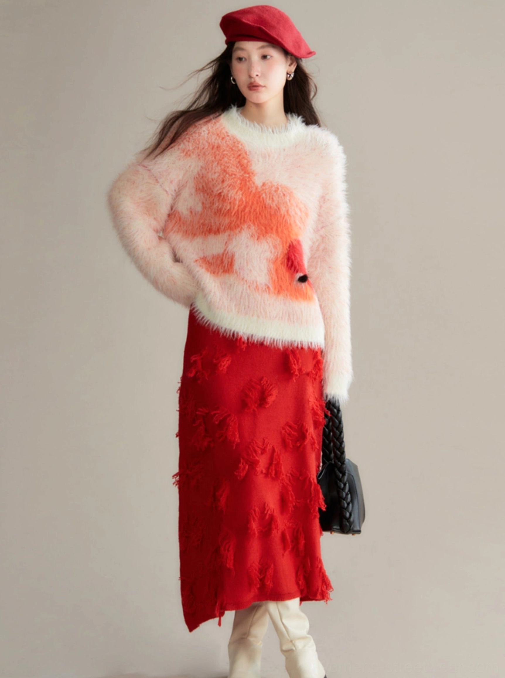 Back view of relaxed fuzzy koi knit sweater styled with red midi skirt, off-white boots, and black shoulder bag