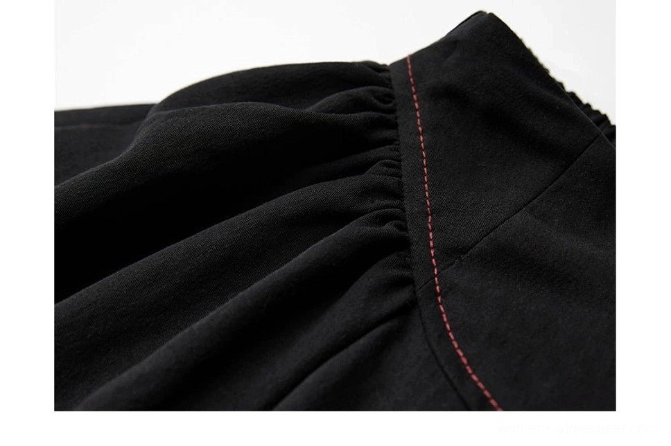 Detailed view of gathered black fabric and red stitching on gothic A-line maxi skirt
