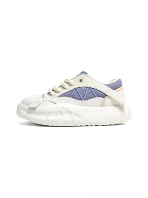 Blue geometric panel platform runner sneaker shown from the left side on a white background, with a cream chunky sole and rounded toe