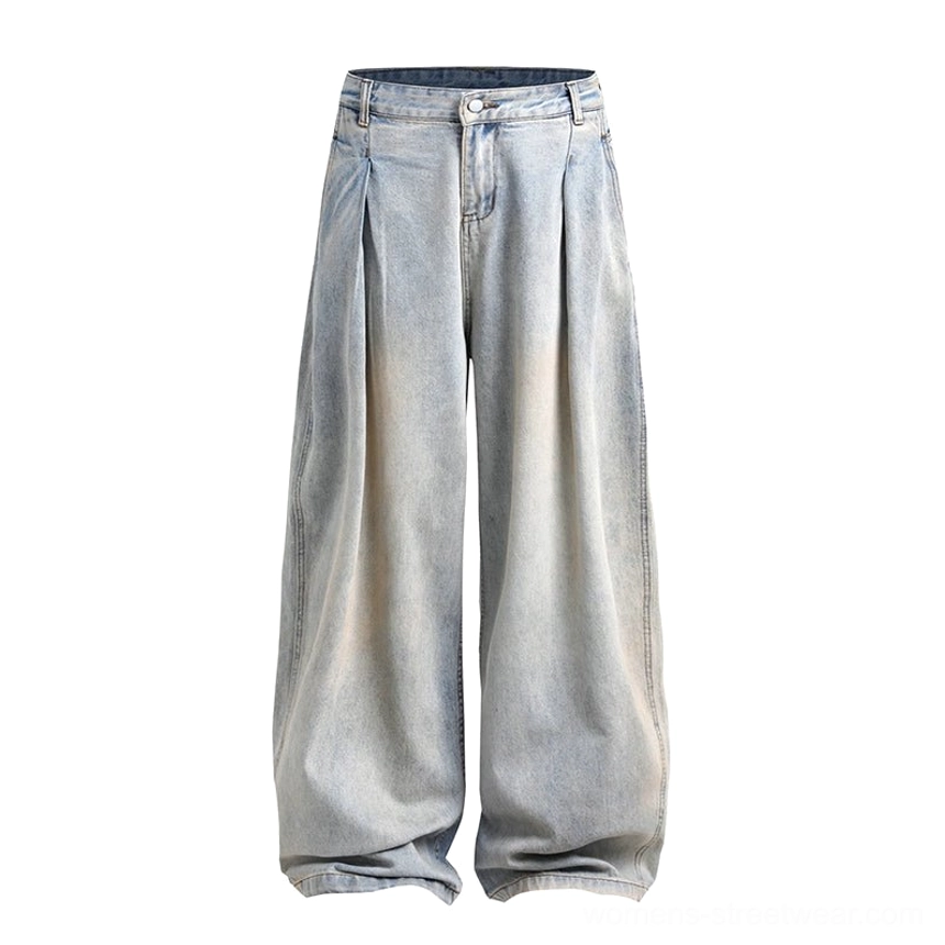 Flat lay of faded light blue women’s ultra-wide pleated jeans showing the oversized A-line cut, vintage yellowed wash, and full-length design