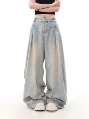 Straight front view of high-waisted women’s wide-leg denim jeans with deep pleats, vintage faded blue wash, and oversized streetwear silhouette