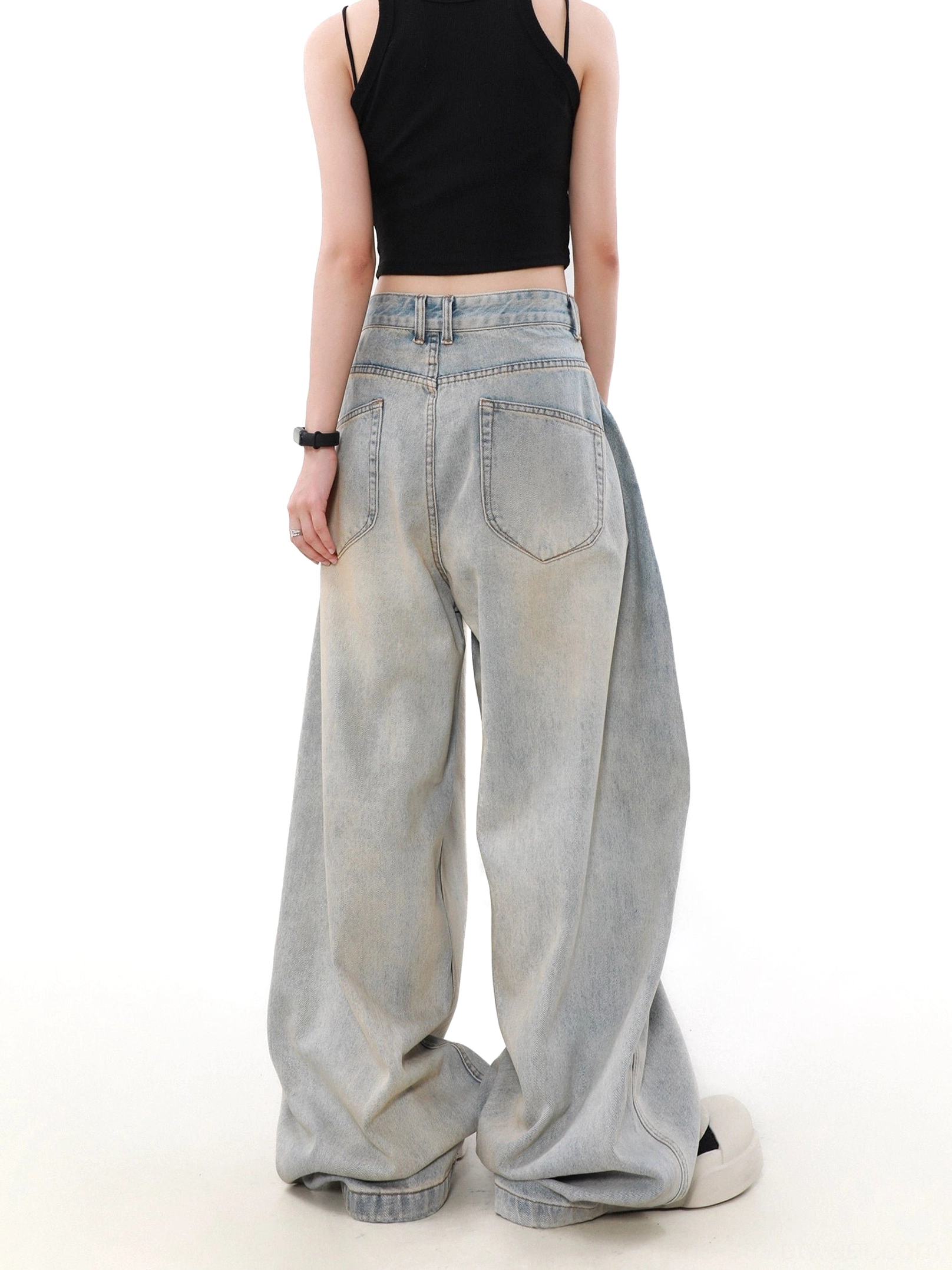 Rear view of women’s ultra-wide faded blue jeans showing rear patch pockets, belt loops, stacked hem, and relaxed Korean streetwear fit