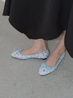 Model wearing glitter star print bow ballet flats with a long black skirt in a casual Korean streetwear outfit