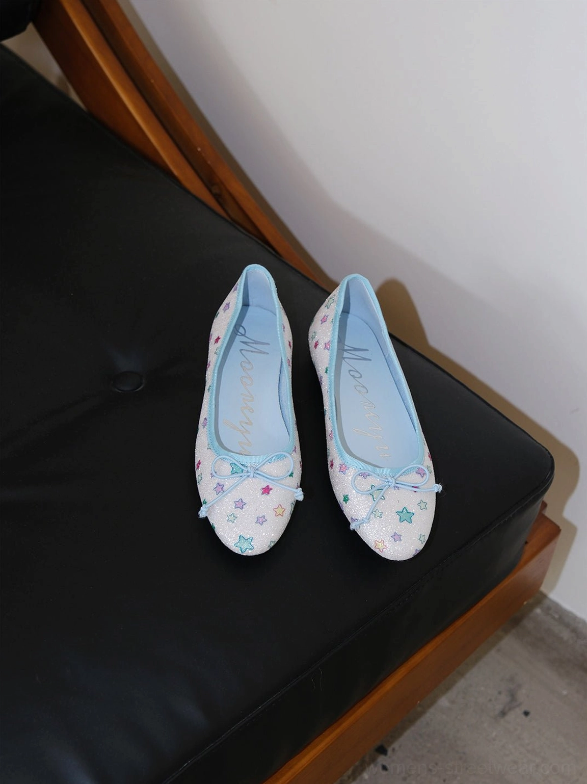 Pair of glitter star print bow ballet flats displayed together showing the colorful star upper and blue insoles