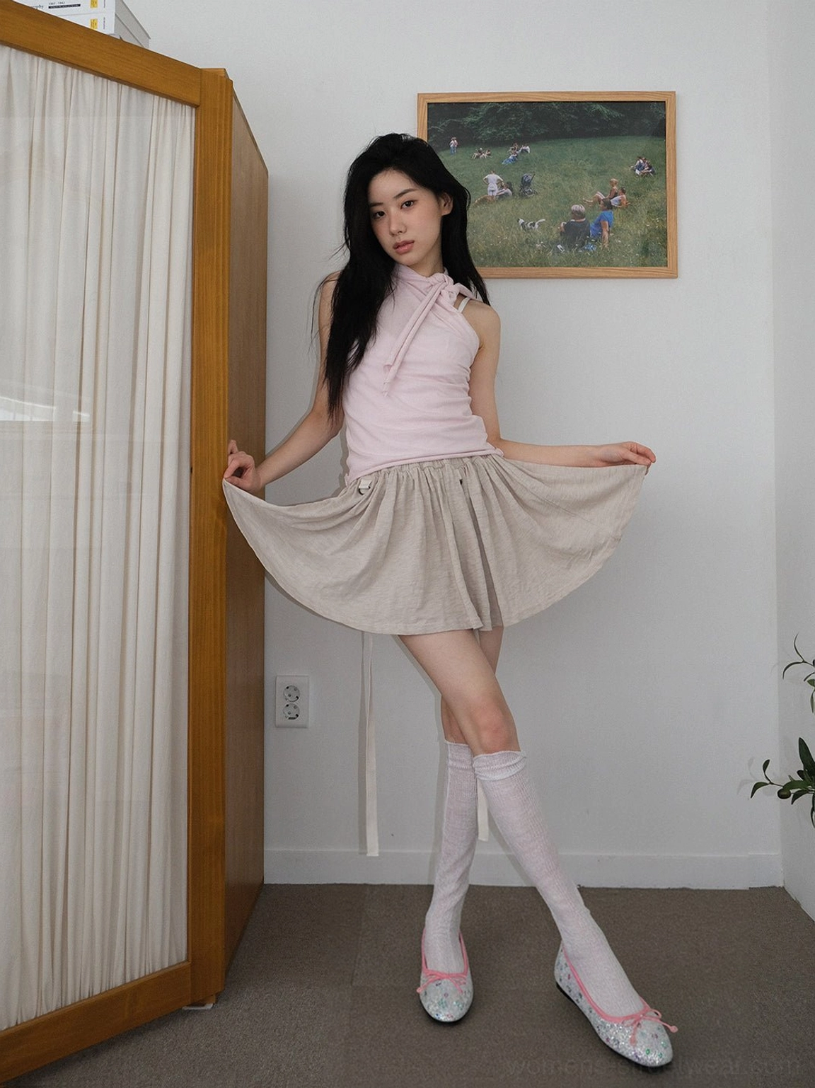 Glitter star print bow ballet flats styled with a pink top, beige pleated skirt, and long white socks