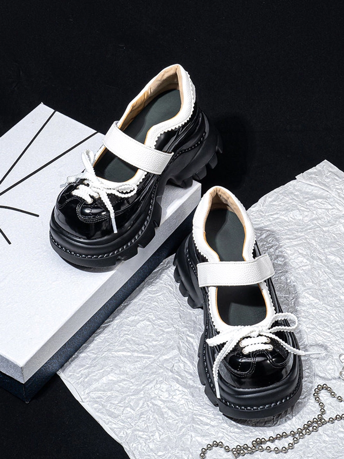 Low angle view of women's glossy platform Mary Jane shoes highlighting the chunky rubber lug outsole and microfiber inner lining