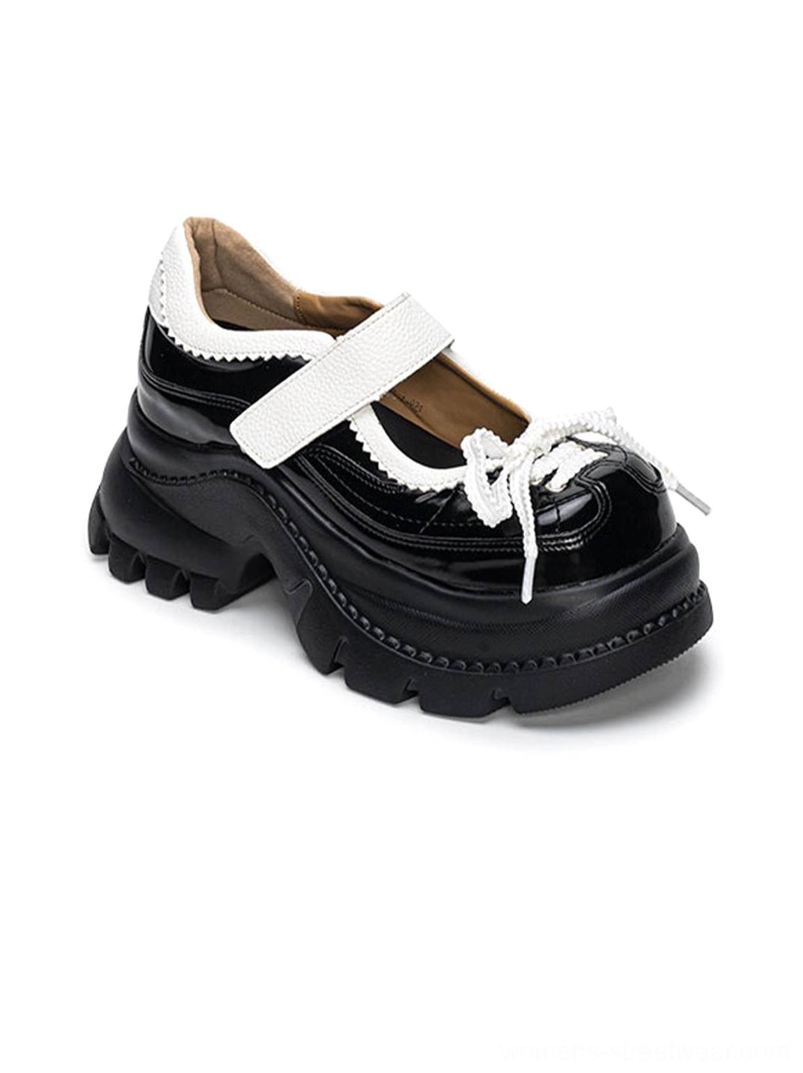 Glossy black and white platform Mary Jane shoes for women with contrast straps, bow lace detail, rounded toe, and chunky lug sole on a white background