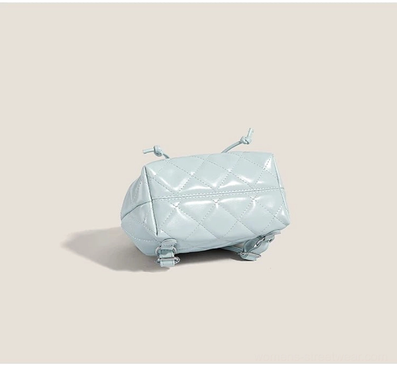 Bottom view of sky blue quilted mini backpack showing protective metal base studs