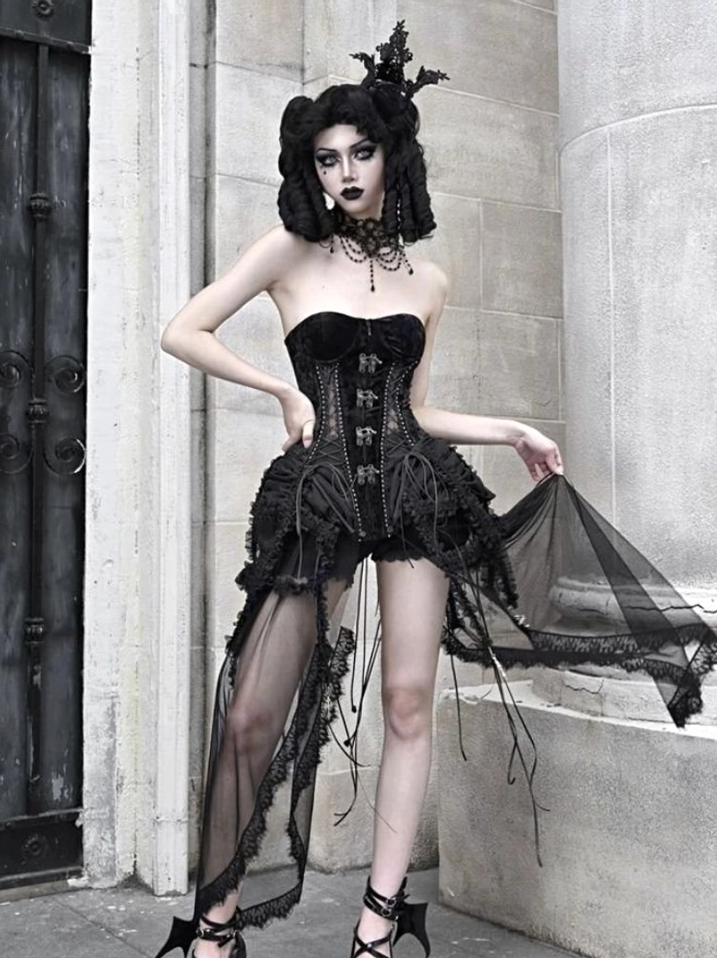 Side-front view of black gothic birdcage corset outfit showing lace-up front detail and asymmetric sheer tulle skirt