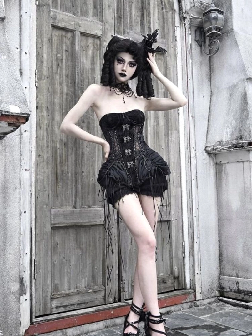 Front view of short gothic black birdcage corset outfit with mini ruffled skirt and lace-up corset closure