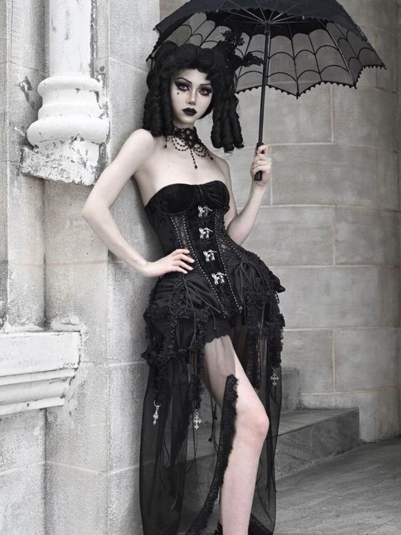 Side view of gothic black birdcage corset three-piece set with metallic corset decorations and ruffled tulle drape