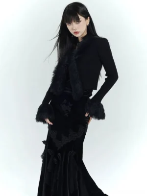 Black gothic faux fur trim cropped ribbed knit cardigan front view styled with a black velvet fishtail skirt in a white studio