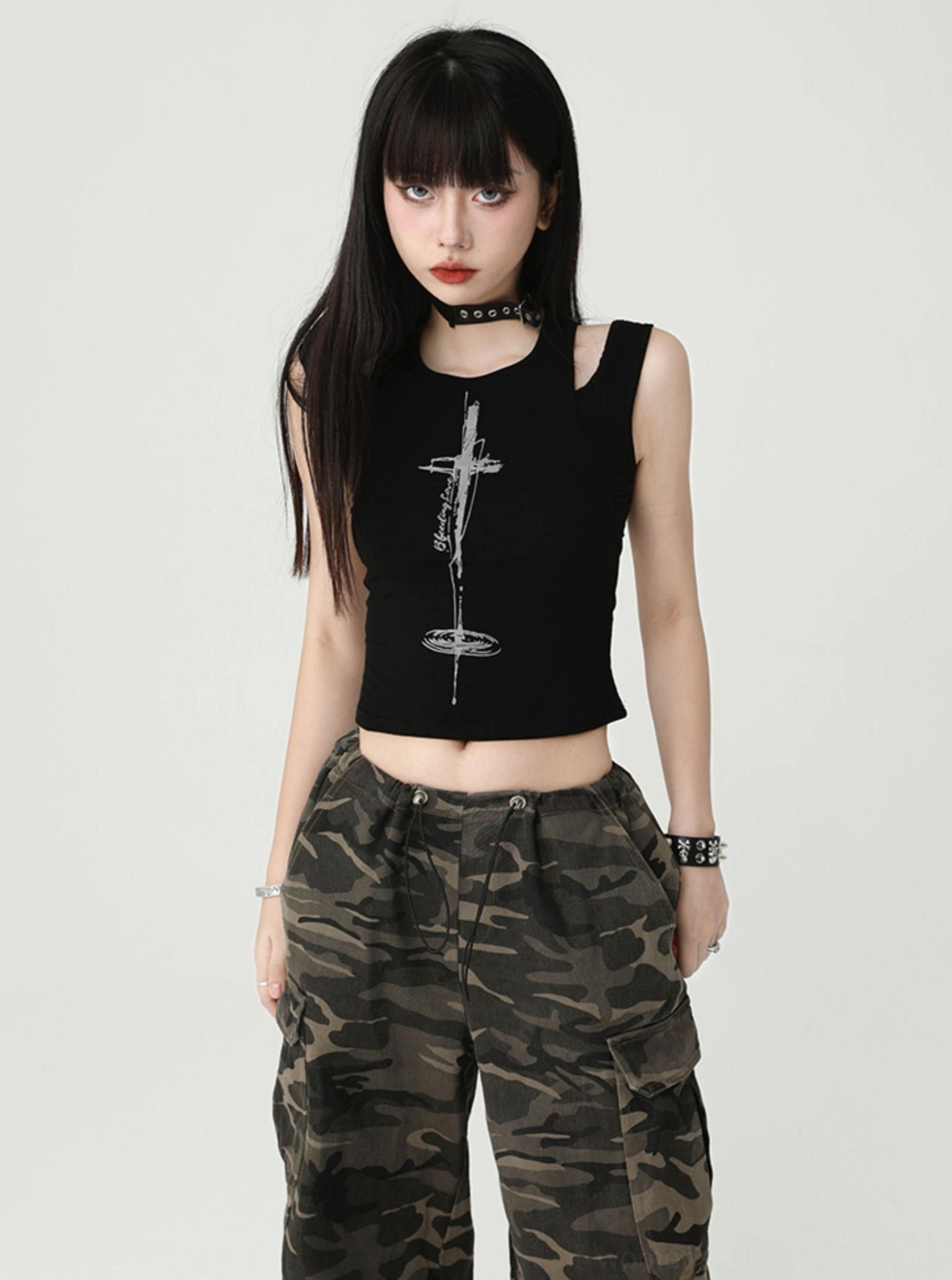 Black gothic cross cutout cropped tank top shown from the front with ribbed fabric, shoulder cutouts, silver cross graphic, and punk streetwear styling