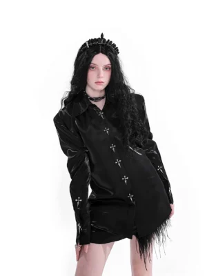 Front view of a glossy black gothic cross embroidered satin shirt with long sleeves, structured shoulders, button-down front, and dramatic feather trim styling