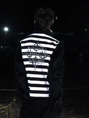 Back view of black and white faux fur striped streetwear shirt featuring large gothic sigil embroidery across the back and textured black sleeves