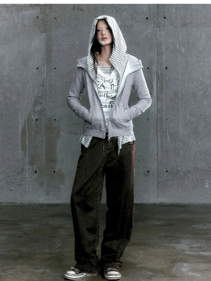 Graffiti layered long sleeve top worn under a cropped gray zip hoodie with dark cargo pants