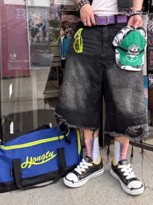 Graphic chunky streetwear sneakers styled with ripped denim shorts and colorful socks in an outdoor urban shop setting