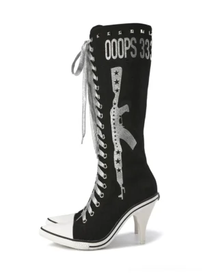 Black graphic print studded tall boots with silver weapon-inspired artwork, lace-up front, white toe cap, and sculptural high heel