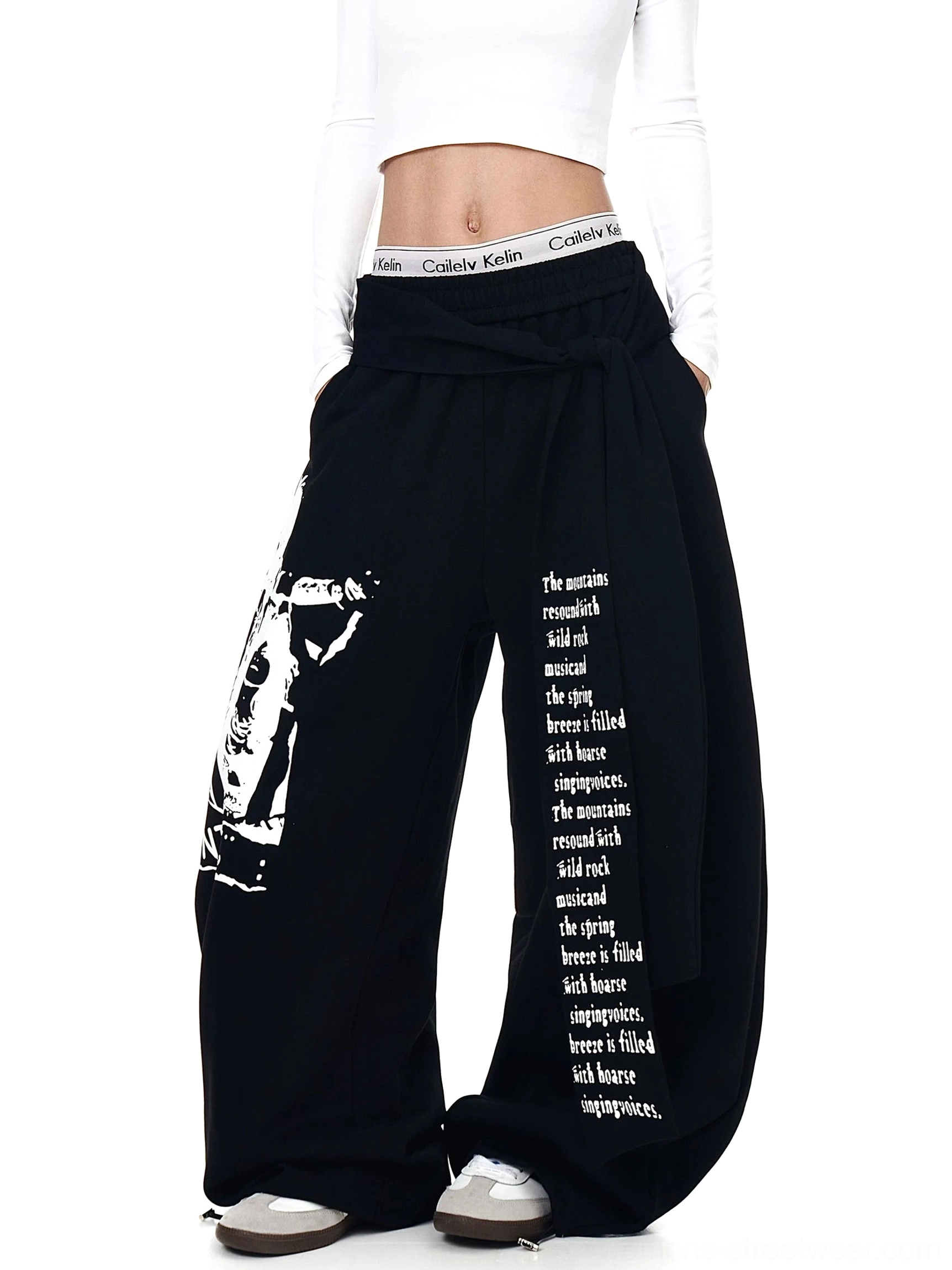 Black graphic wrap panel ultra wide leg streetwear sweatpants front view with tied waist detail and printed legs