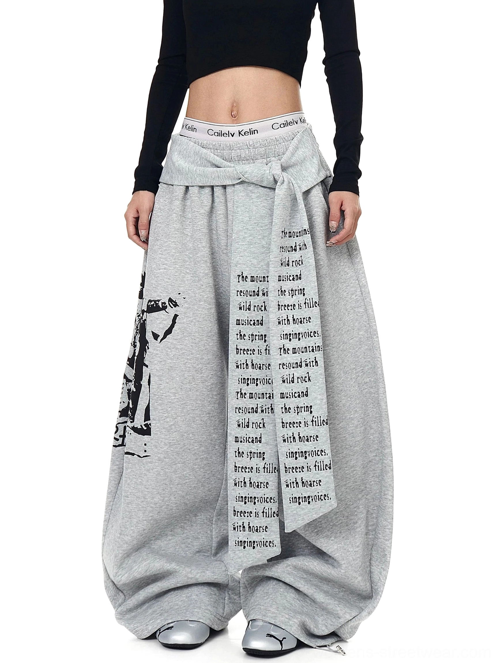 Gray graphic wrap panel fleece sweatpants with oversized puddle legs and vertical text print front view
