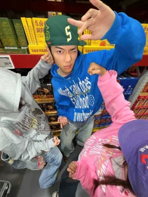 Blue and Flower Gray graphic zip-up hoodies shown in a playful overhead streetwear outfit scene inside a supermarket