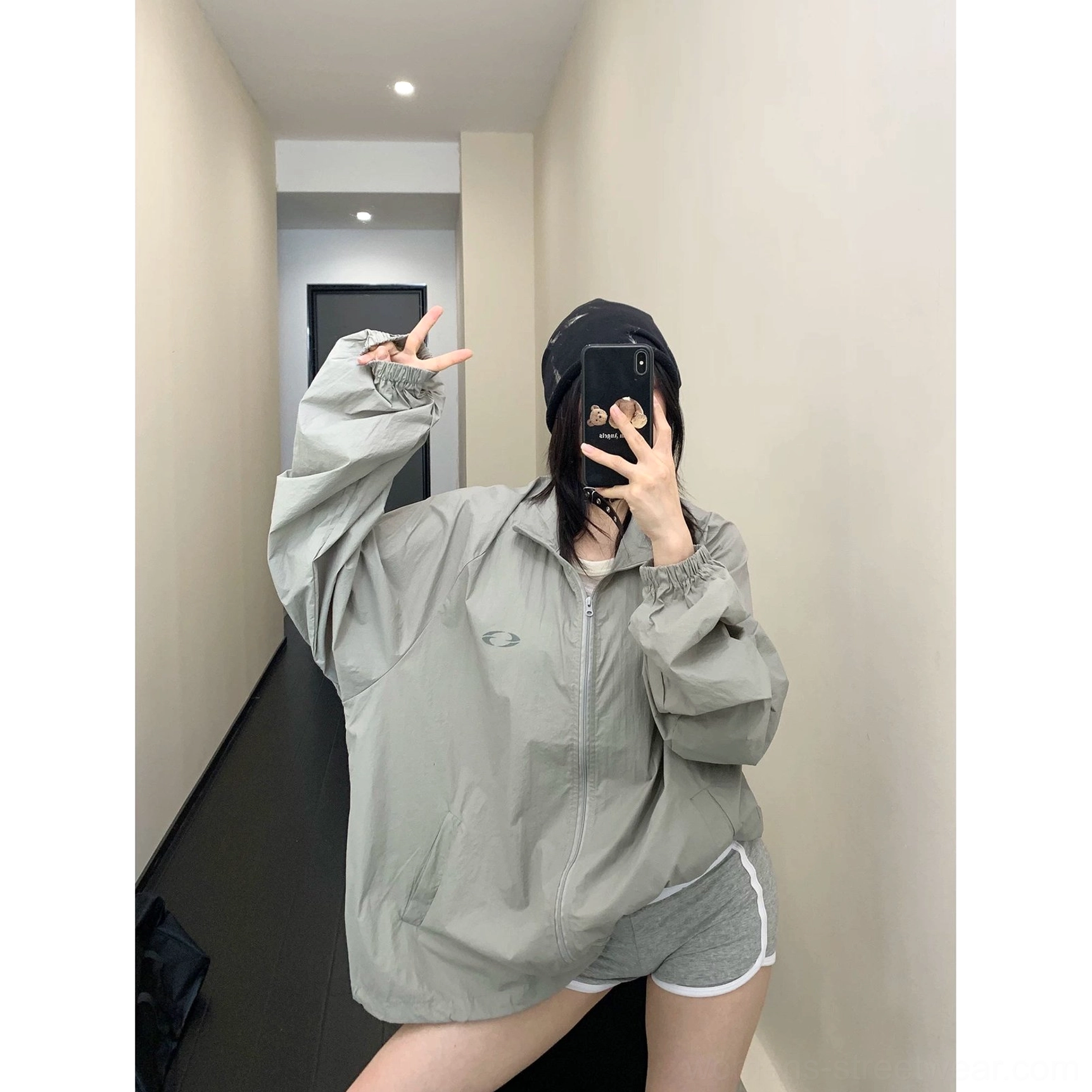 Front mirror view of an oversized gray windbreaker jacket with high stand collar, full front zipper, chest logo, elastic cuffs, and roomy Acubi-inspired fit