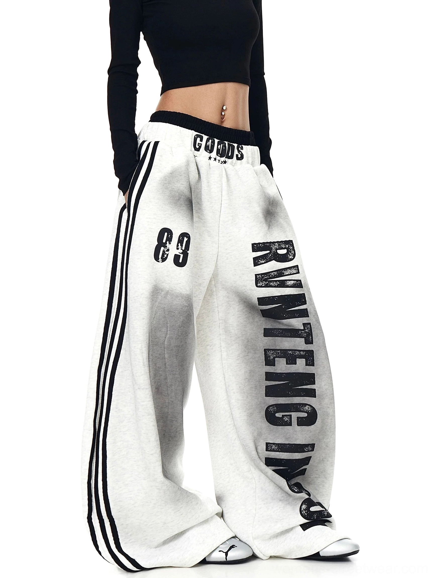 Three-quarter view of heather gray baggy fleece sweatpants with wide legs, vertical graphic print, 89 detail, and black side stripes