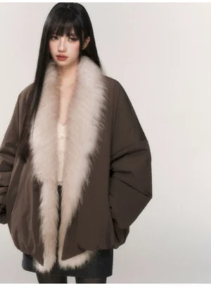 Gray brown oversized padded parka with a dramatic pale faux fur shawl collar shown in a half body front close-up view