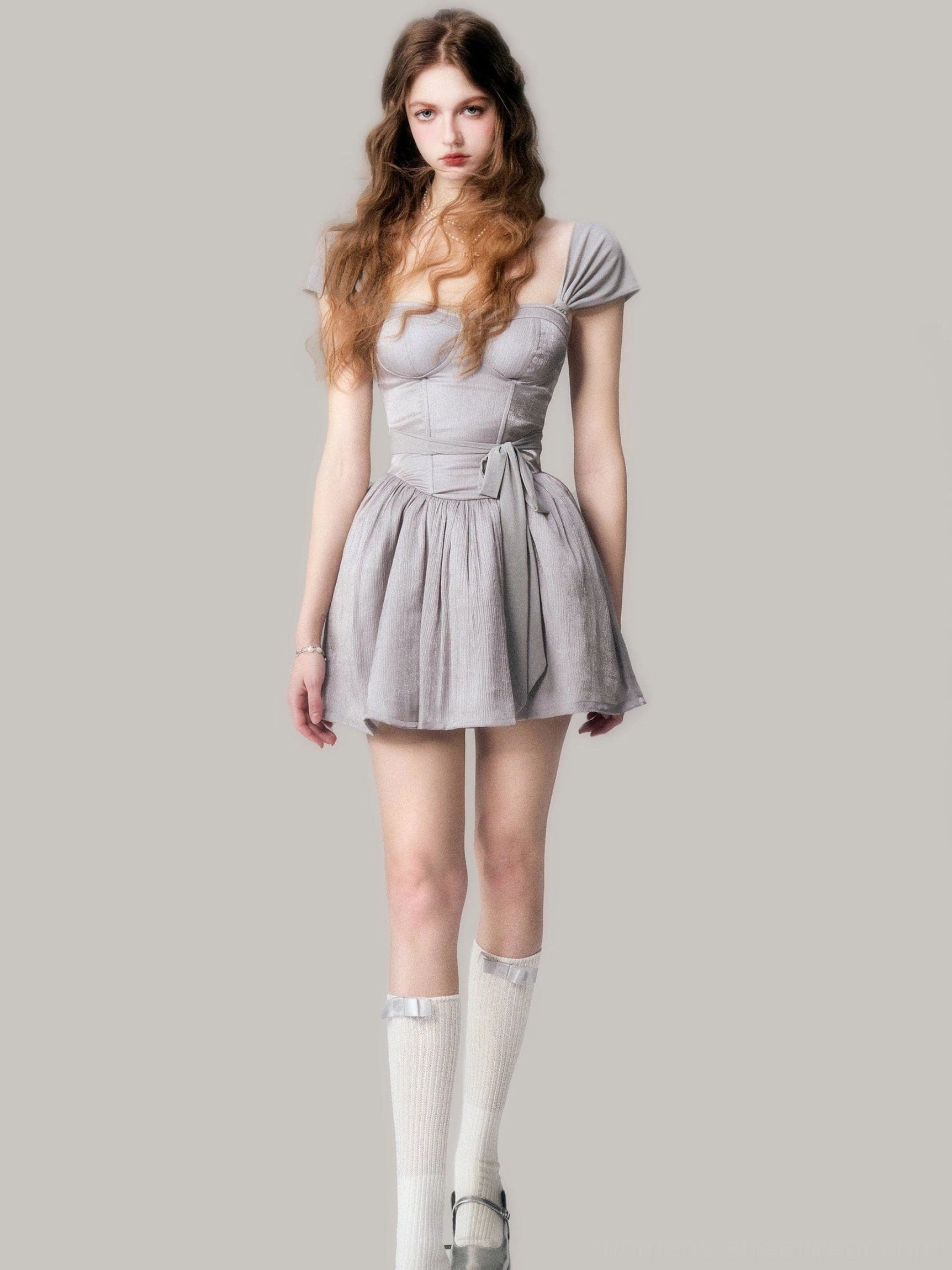 Front three quarter view of a gray cap sleeve corset mini dress with structured bustier bodice and pleated skirt