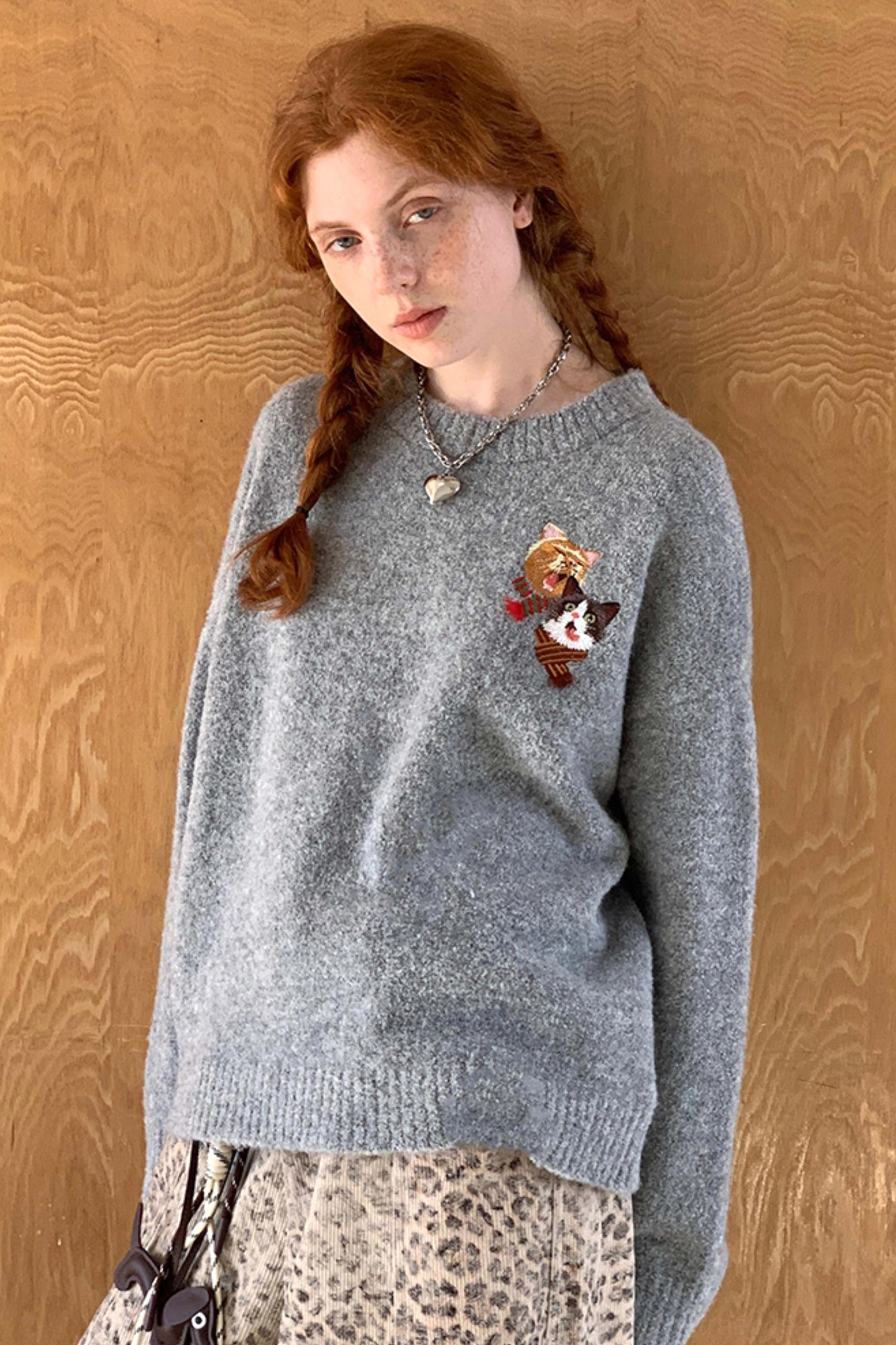 Gray cat embroidered knit sweater with relaxed crewneck silhouette styled with leopard print skirt