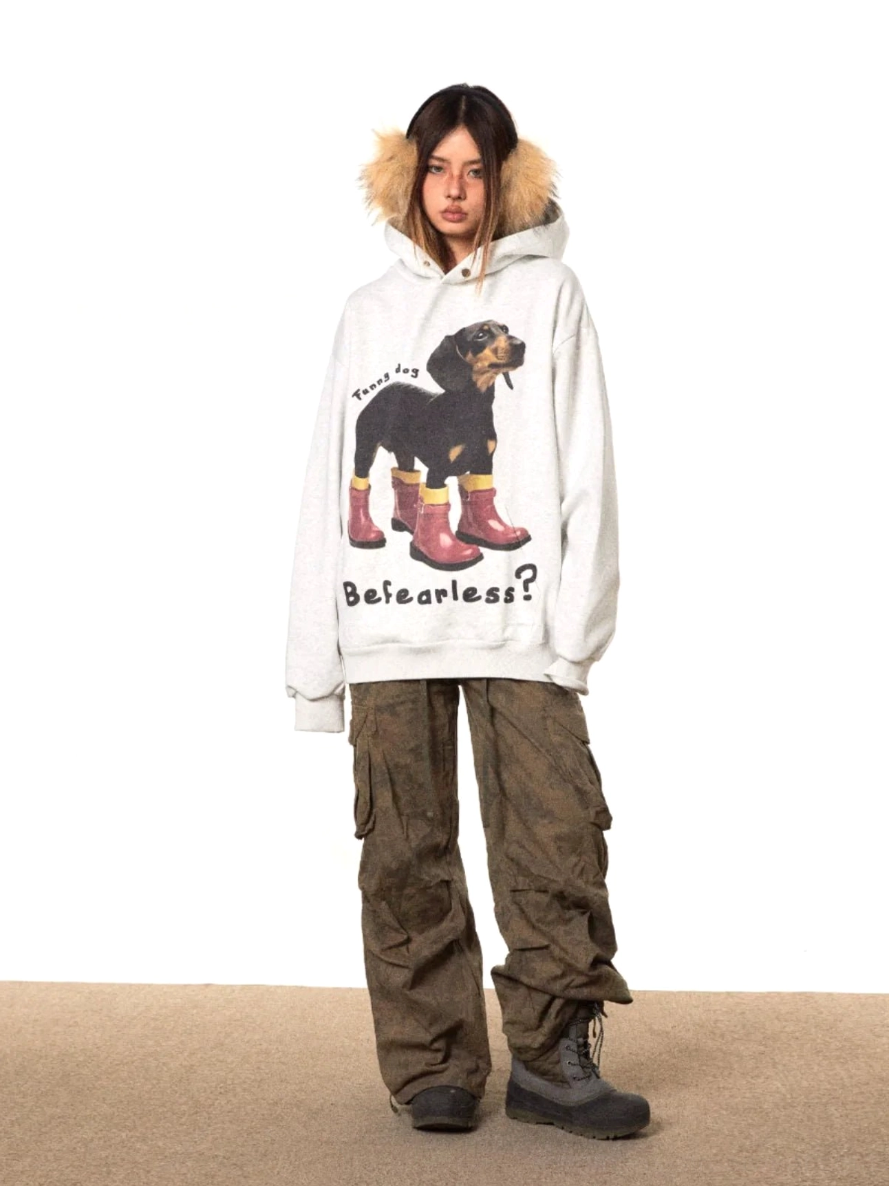 Full front view of a loose gray dog print oversized hoodie featuring a dachshund illustration, red rain boots, and fearless graphic text